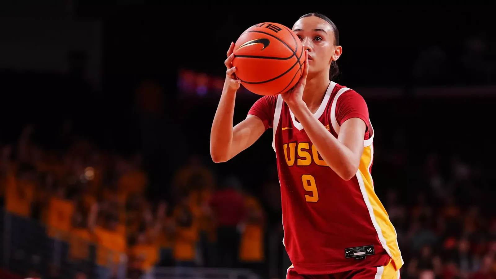 USC women's basketball player in a red number 9 jersey preparing to shoot a free throw