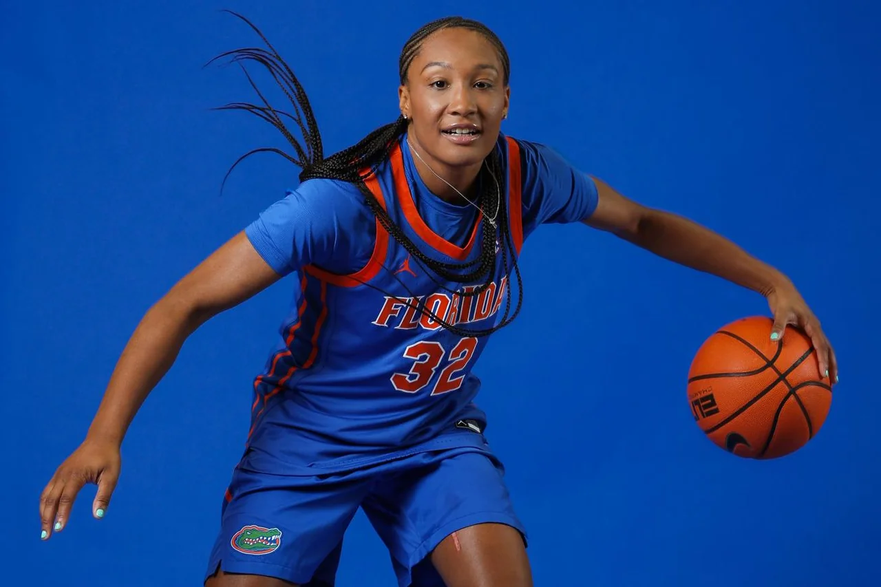 Florida Gators women's basketball: player smiling while dribbling in a studio portrait
