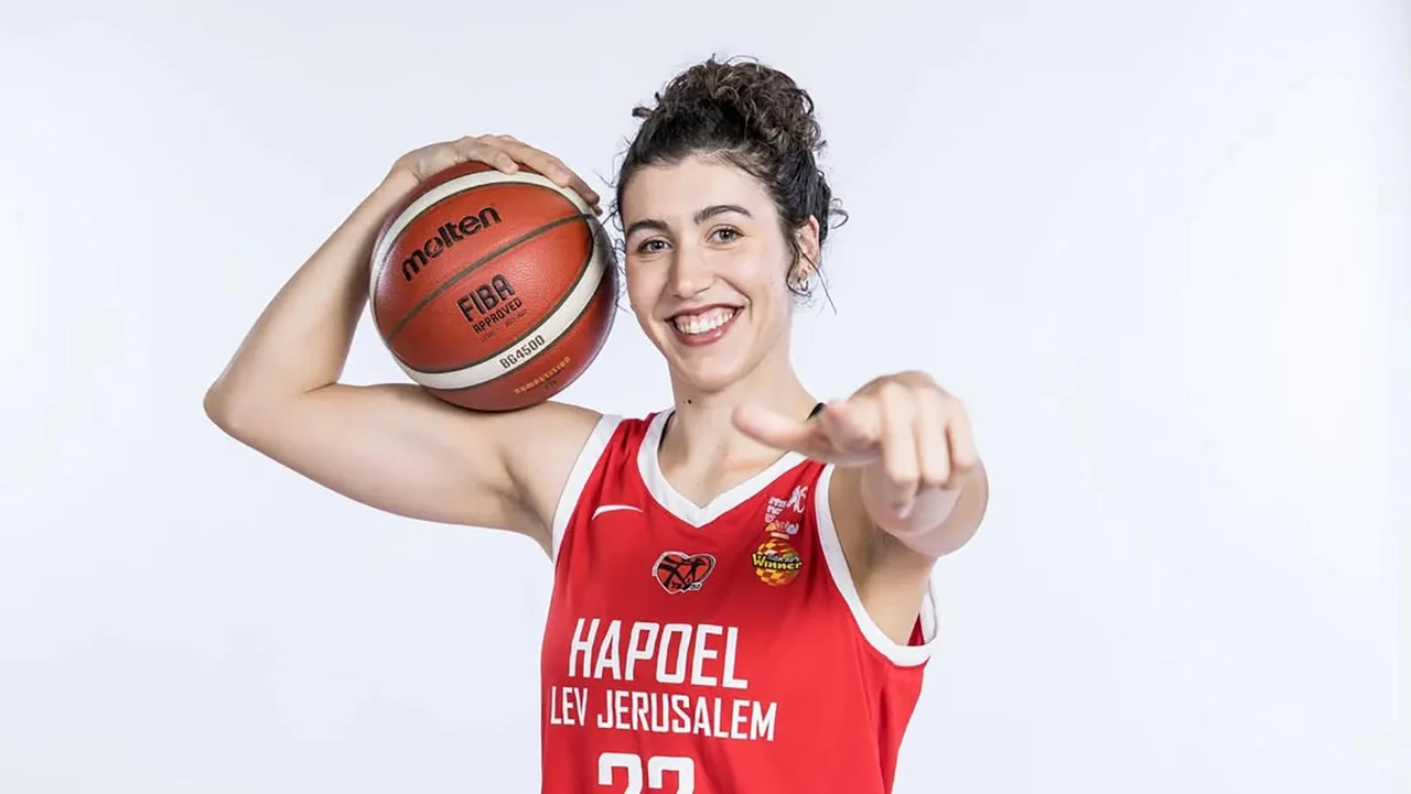 Kansas State Wildcats women's basketball: article photo of a player posing with a basketball in a red uniform