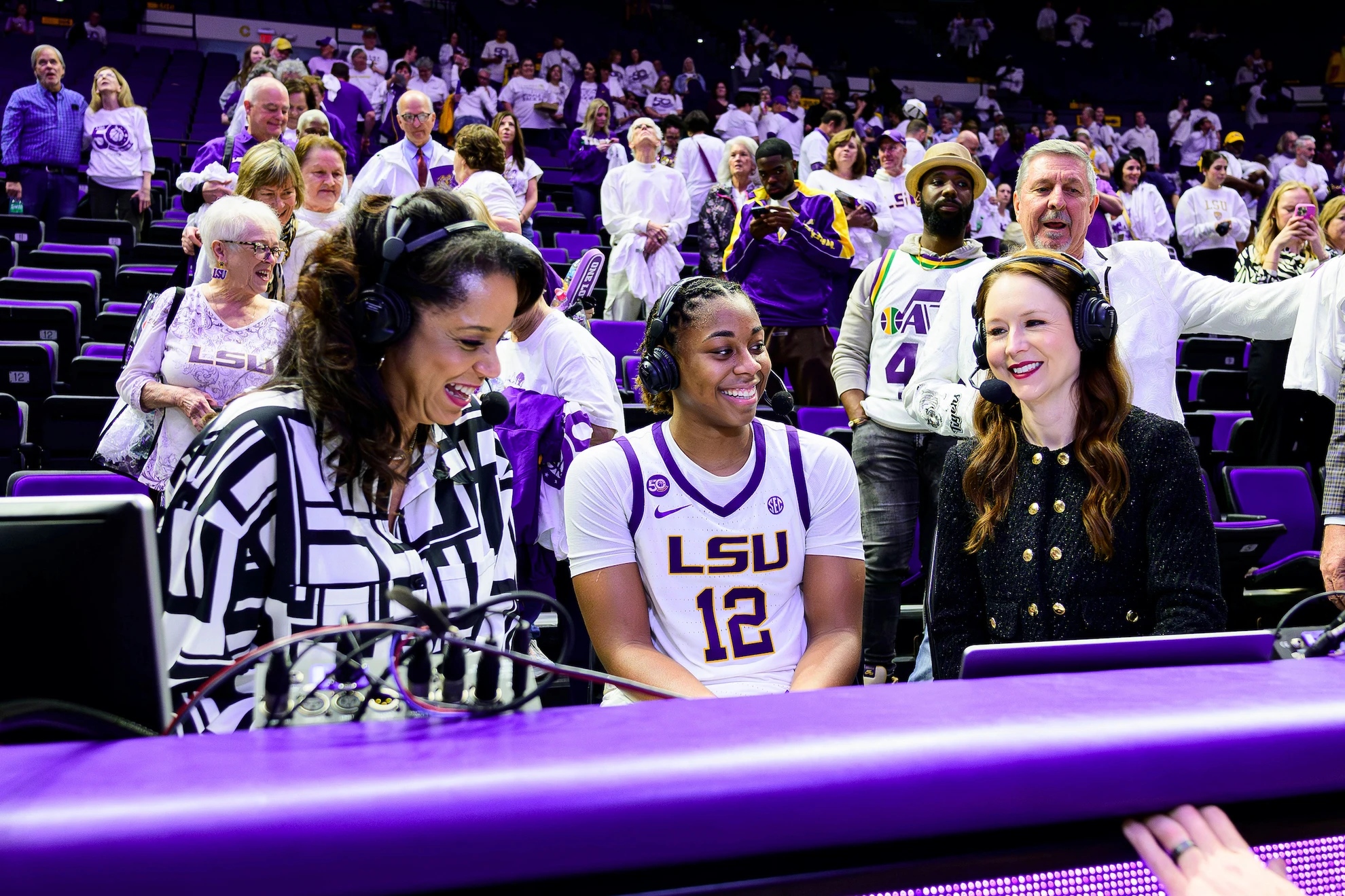 An LSU Tigers player posing with family, coaching staff and the team mascot during a senior day ceremony