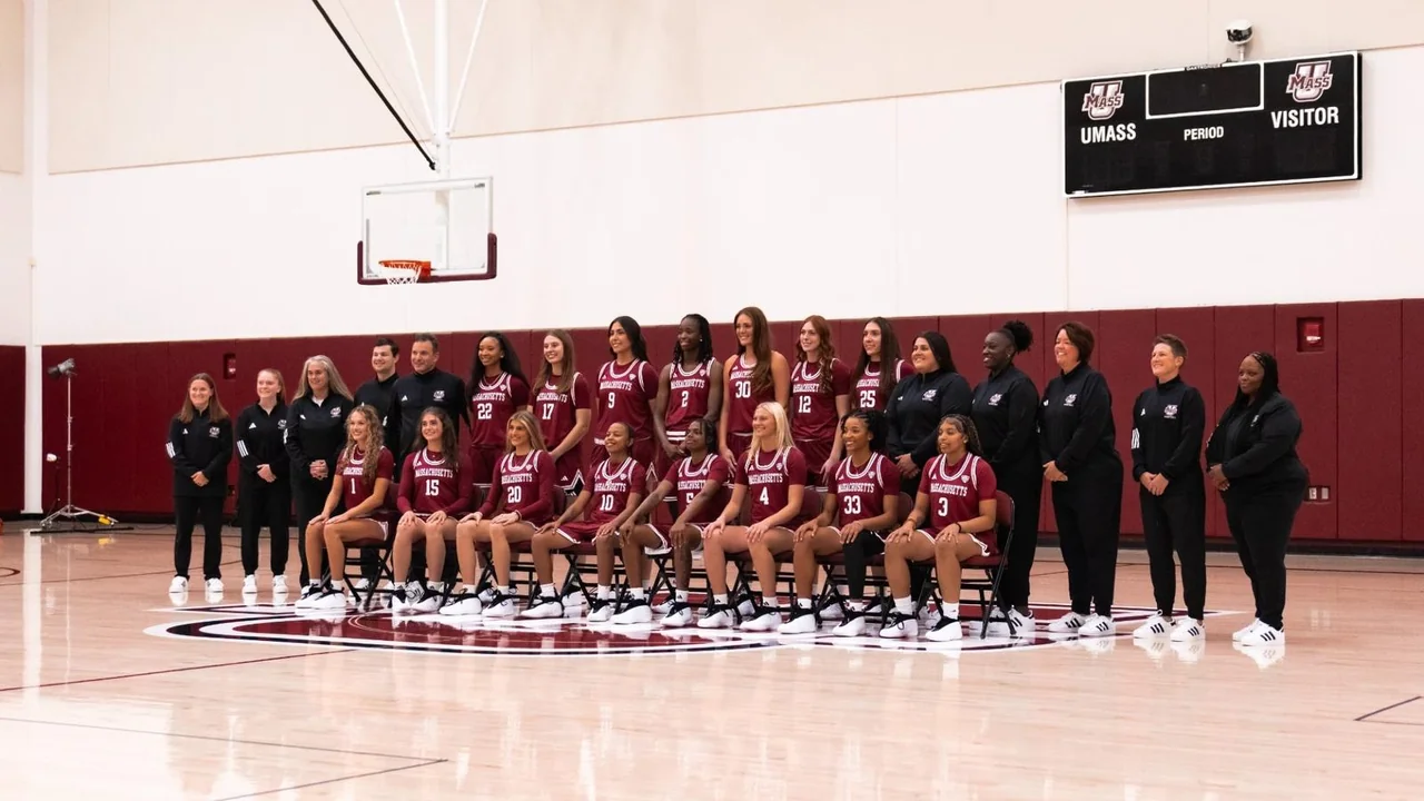 Massachusetts Minutewomen women's basketball: players and staff posing together on the basketball court