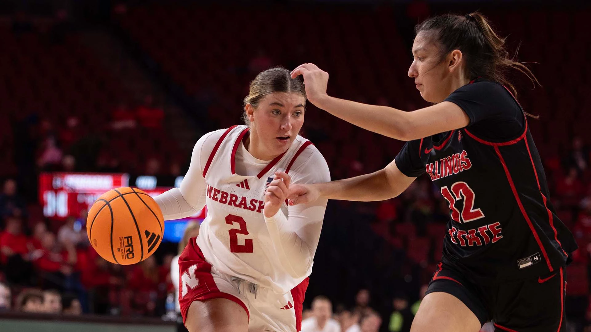 Nebraska Cornhuskers guard driving past an Illinois State defender during a home game at Pinnacle Bank Arena