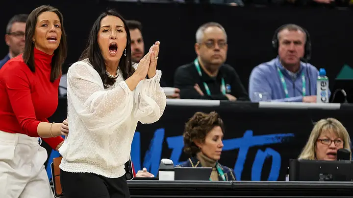 Nebraska head coach Amy Williams applauding from the sideline during an NCAA Tournament game