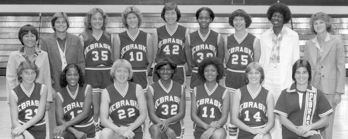 Archival black-and-white team photo of an early Nebraska Cornhuskers women's basketball squad with coaching staff