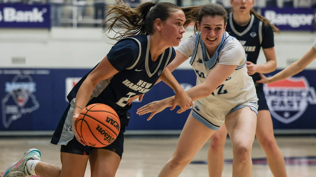 New Hampshire Wildcats women's basketball: player dribbling while an opponent guards closely