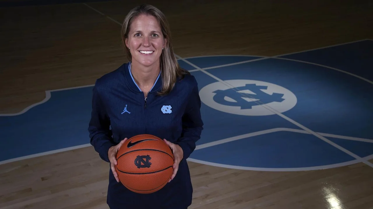 North Carolina Tar Heels women's basketball: coach holding a basketball on the home court