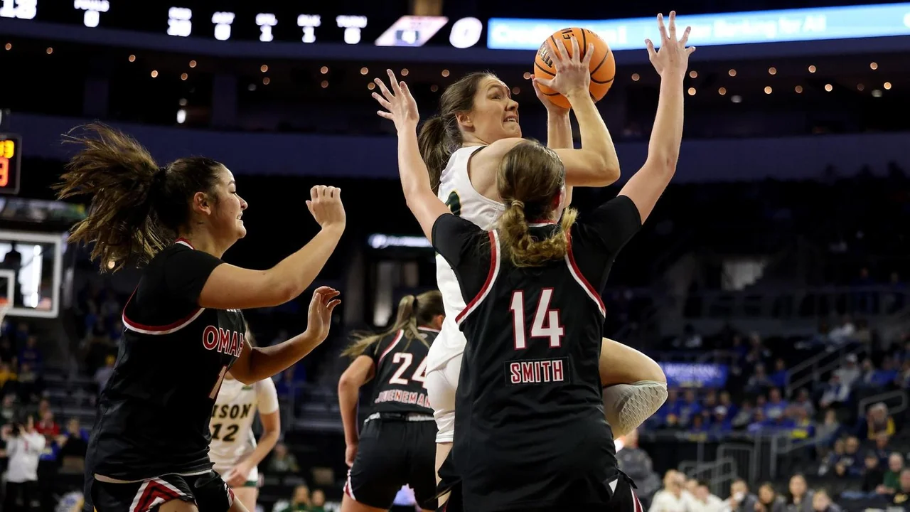 Omaha Mavericks women's basketball: players reaching upward together in a team huddle