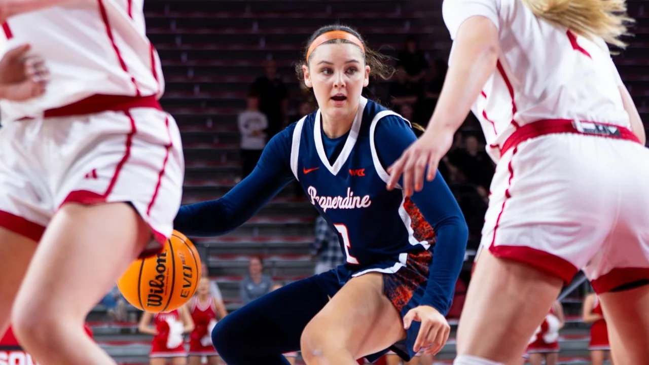 Pepperdine Waves women's basketball: player dribbling between defenders during a game