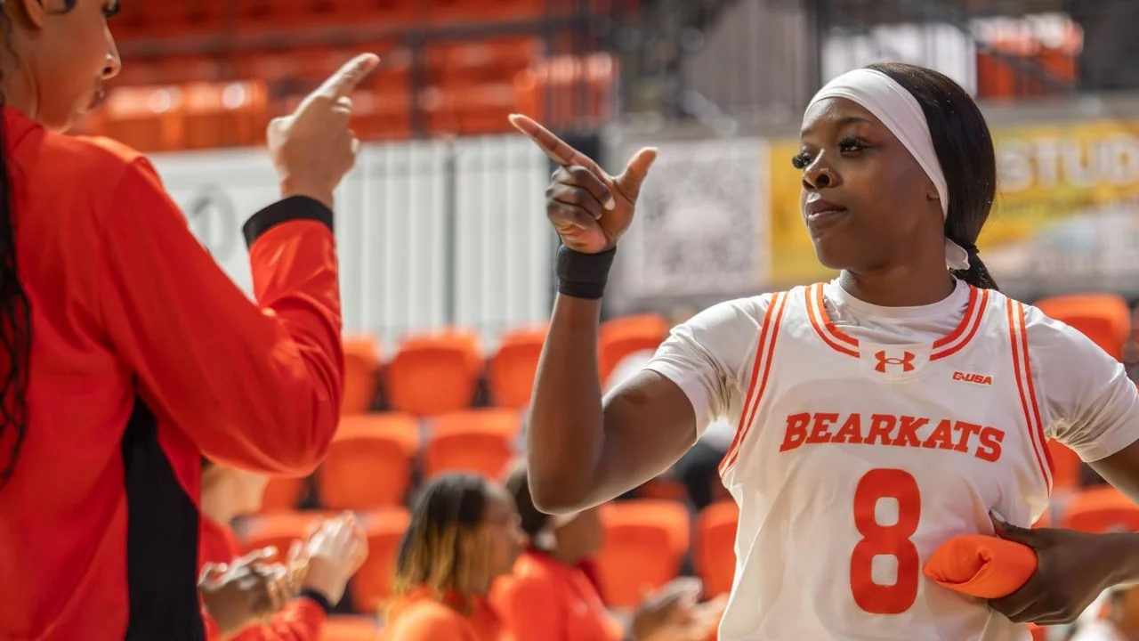 Sam Houston Bearkats women's basketball: player speaking with a coach beside the court