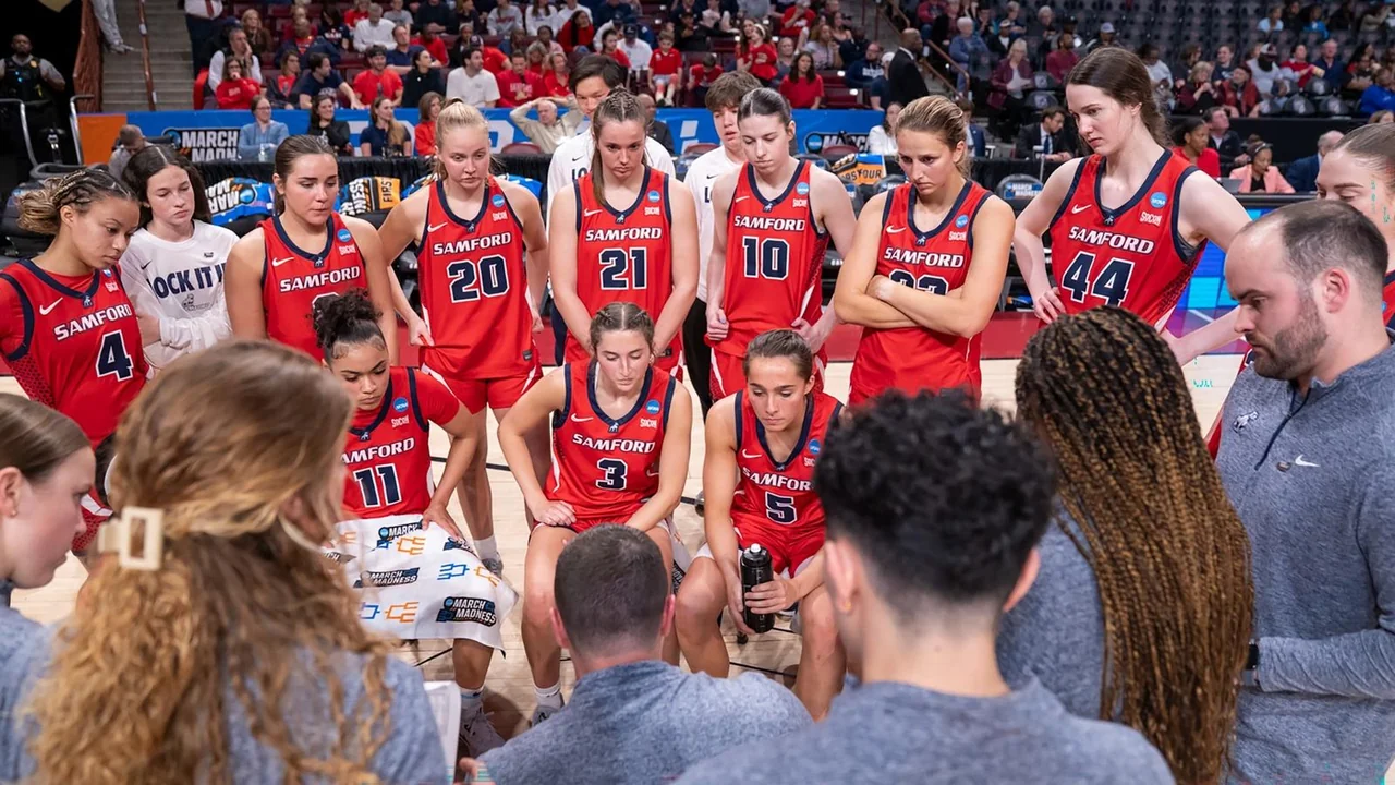 Samford Bulldogs women's basketball: players celebrating in a huddle with their coaches