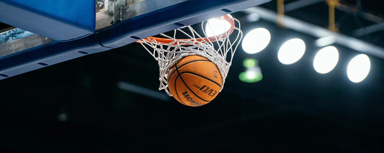 San José State Spartans women's basketball: basketball dropping through a net beneath arena lights