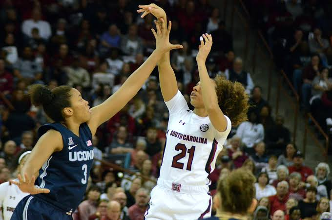 South Carolina Gamecocks guard shooting a contested jump shot over a UConn defender