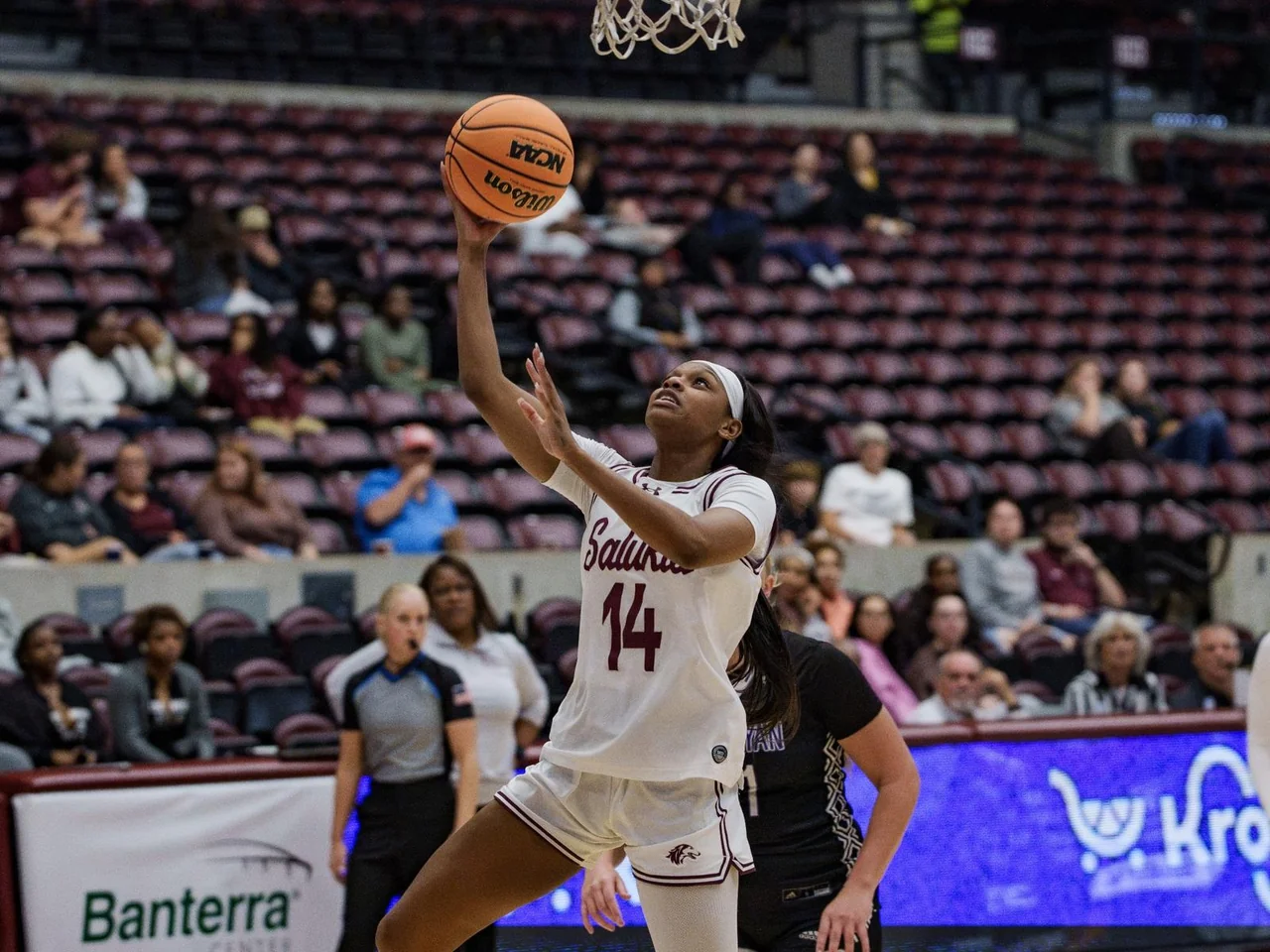 Southern Illinois Salukis women's basketball: player holding the ball while opponents defend