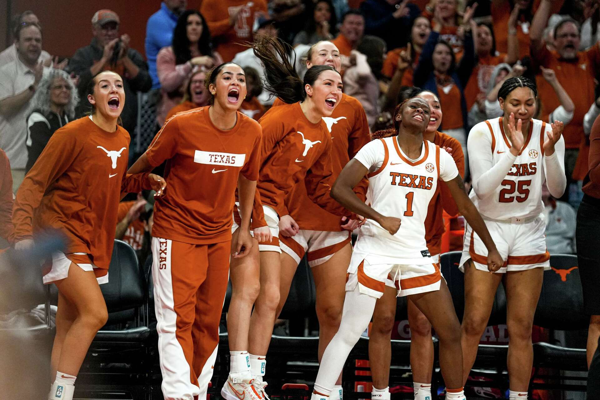 Texas Longhorns bench players celebrating enthusiastically during a home game