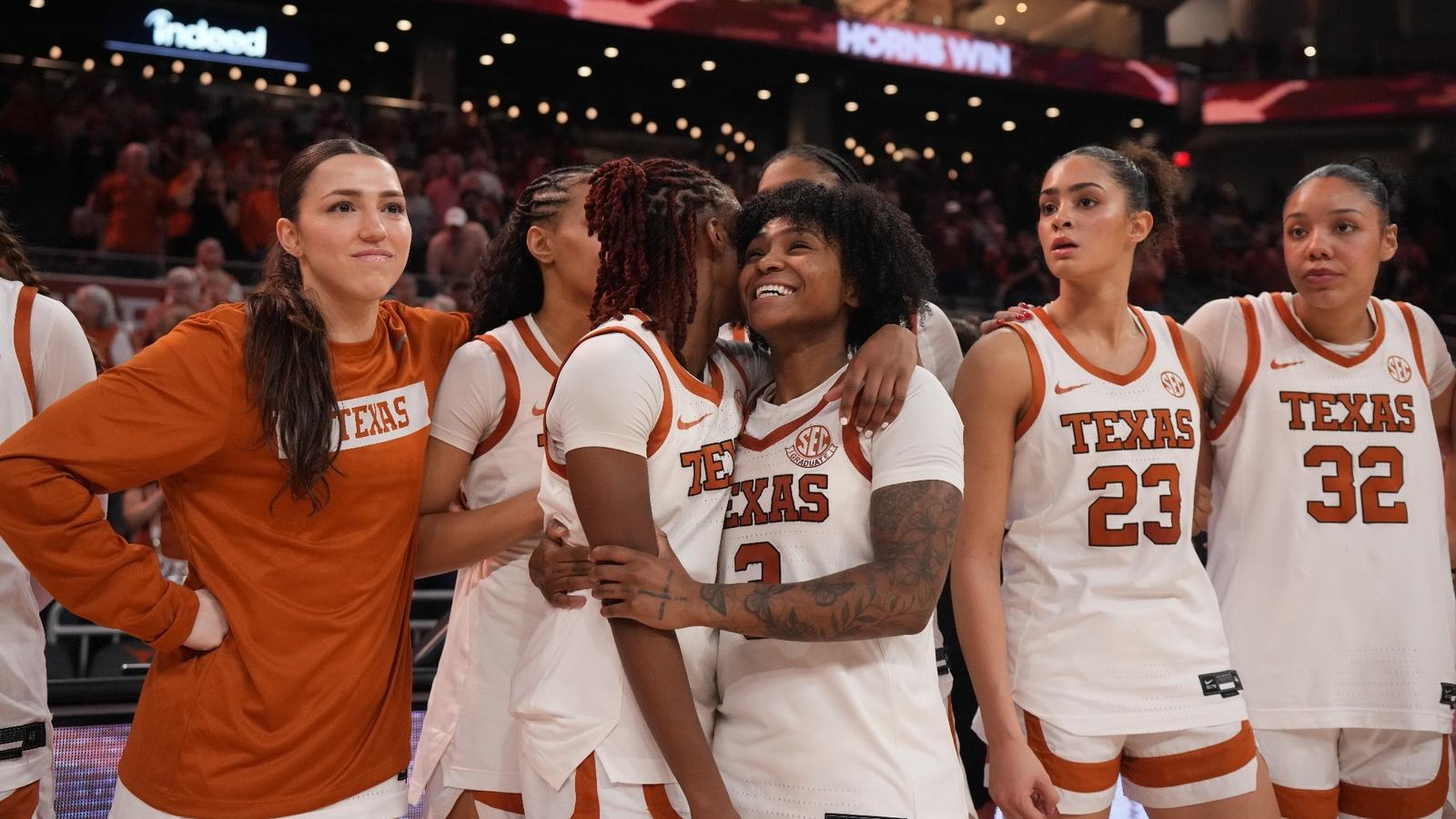 Texas Longhorns players embracing each other in an emotional moment on the court