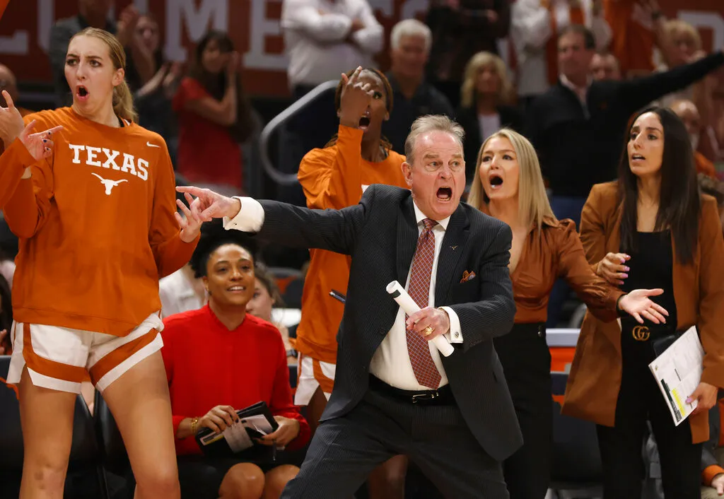 Texas head coach Vic Schaefer animatedly directing his team from the sideline during a game