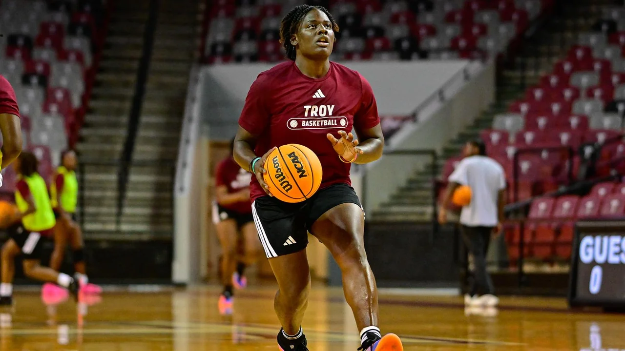 Troy Trojans women's basketball: player holding the basketball in a red Troy uniform
