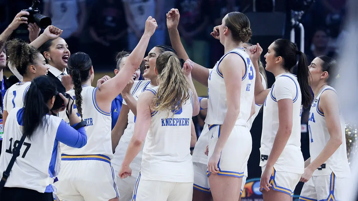 UCLA Bruins players celebrating together on the court after a Final Four win