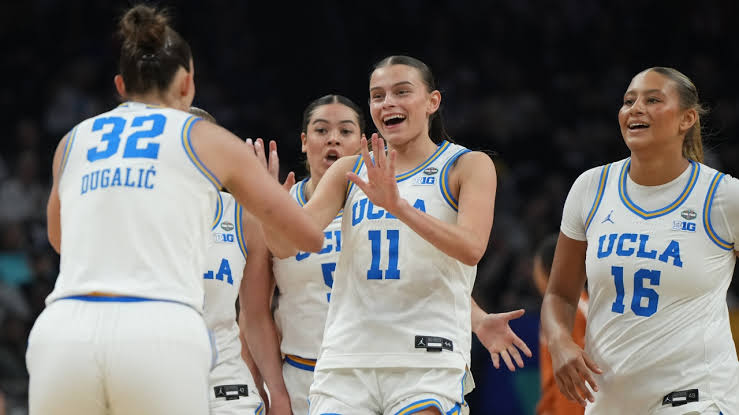 UCLA Bruins players high-fiving each other on the court during a game