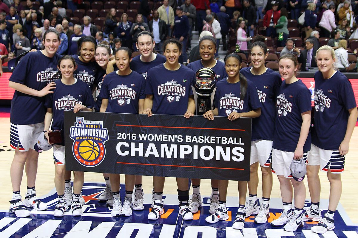 UConn Huskies players posing with the trophy and a banner after winning the 2016 American Athletic Conference championship