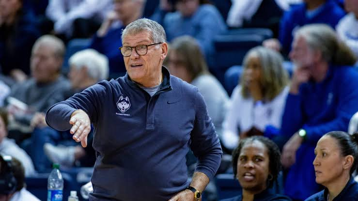 UConn head coach Geno Auriemma directing his team from the sideline during a game