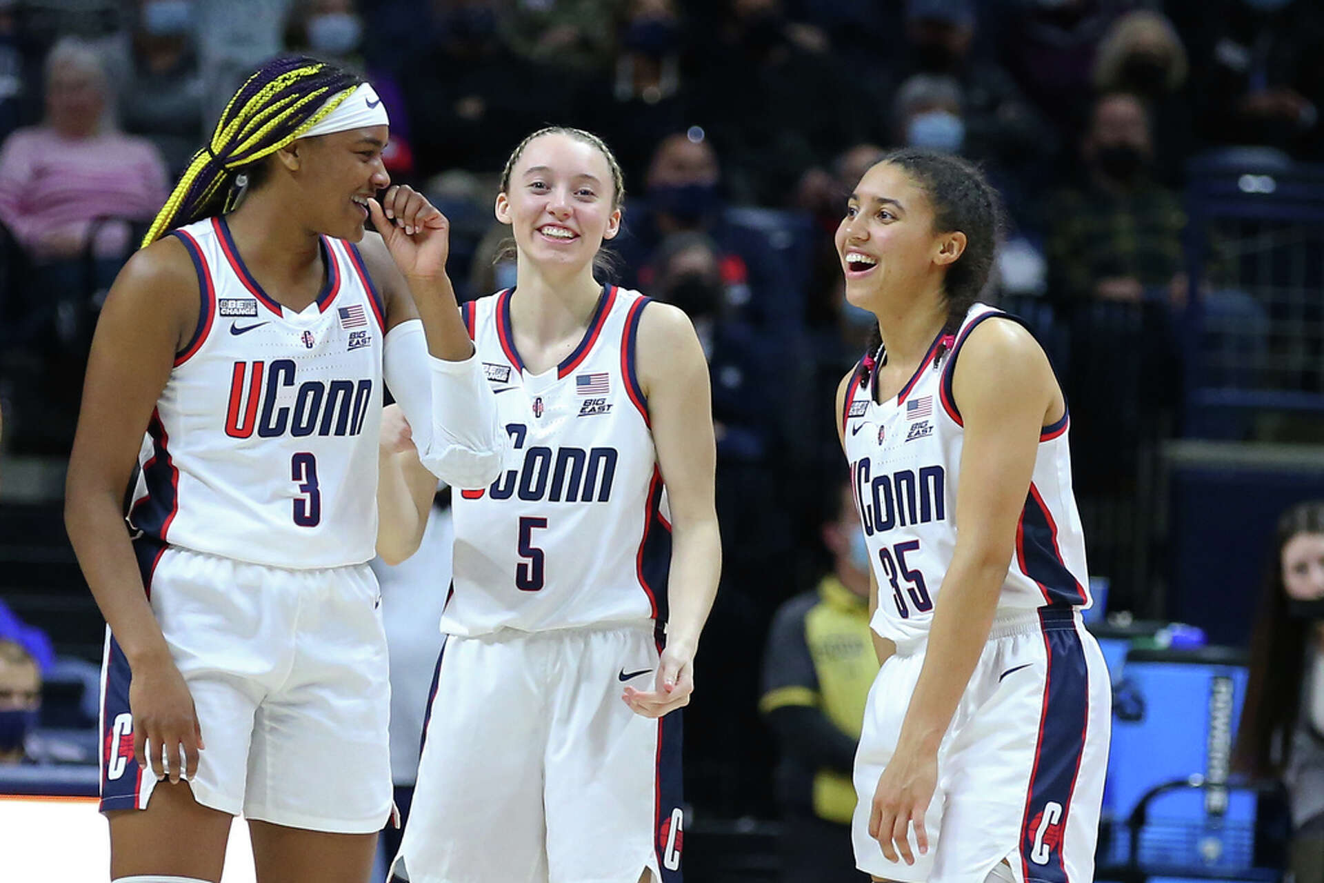 UConn Huskies players laughing together on the court during a game