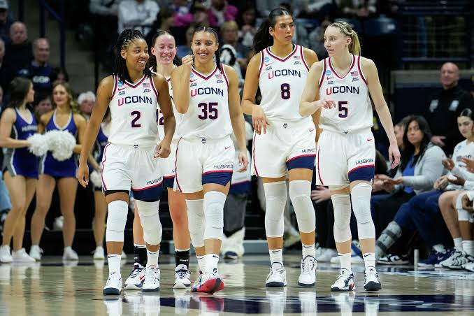 UConn Huskies players walking together across the court during a game
