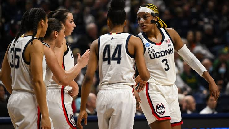 UConn Huskies players huddled together on the court during an NCAA Tournament game