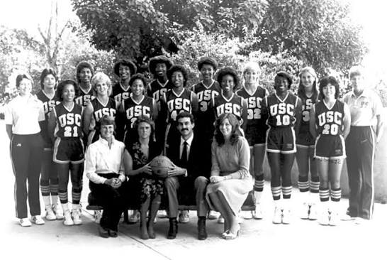 Archival black-and-white team photo of an early USC women's basketball squad posing outdoors with coaching staff