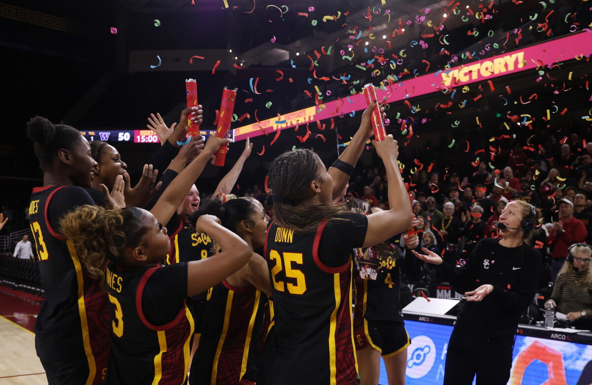 USC Trojans players celebrating a home victory with confetti falling from the arena rafters