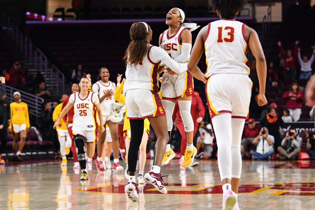 USC Trojans players jumping and celebrating together after a big play at the Galen Center