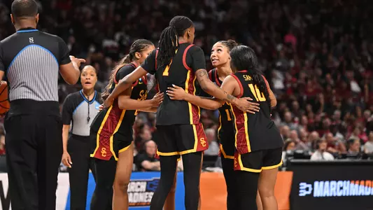 USC Trojans players huddled together celebrating during an NCAA Tournament game